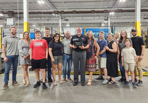 Rob Ernesti, center, poses with his family at MetalWorks as he was awarded the 2025 Distinguished Alumni Award for the Milford Campus. 