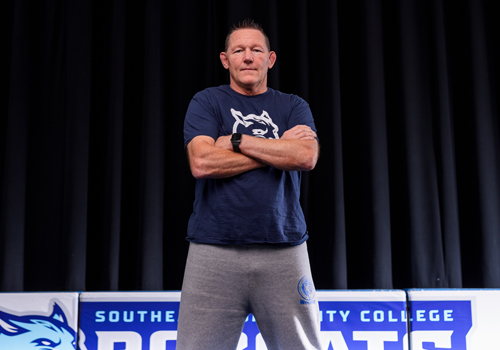 Head Wrestling Coach Terry Pack standing in power pose at the Truman Center. 