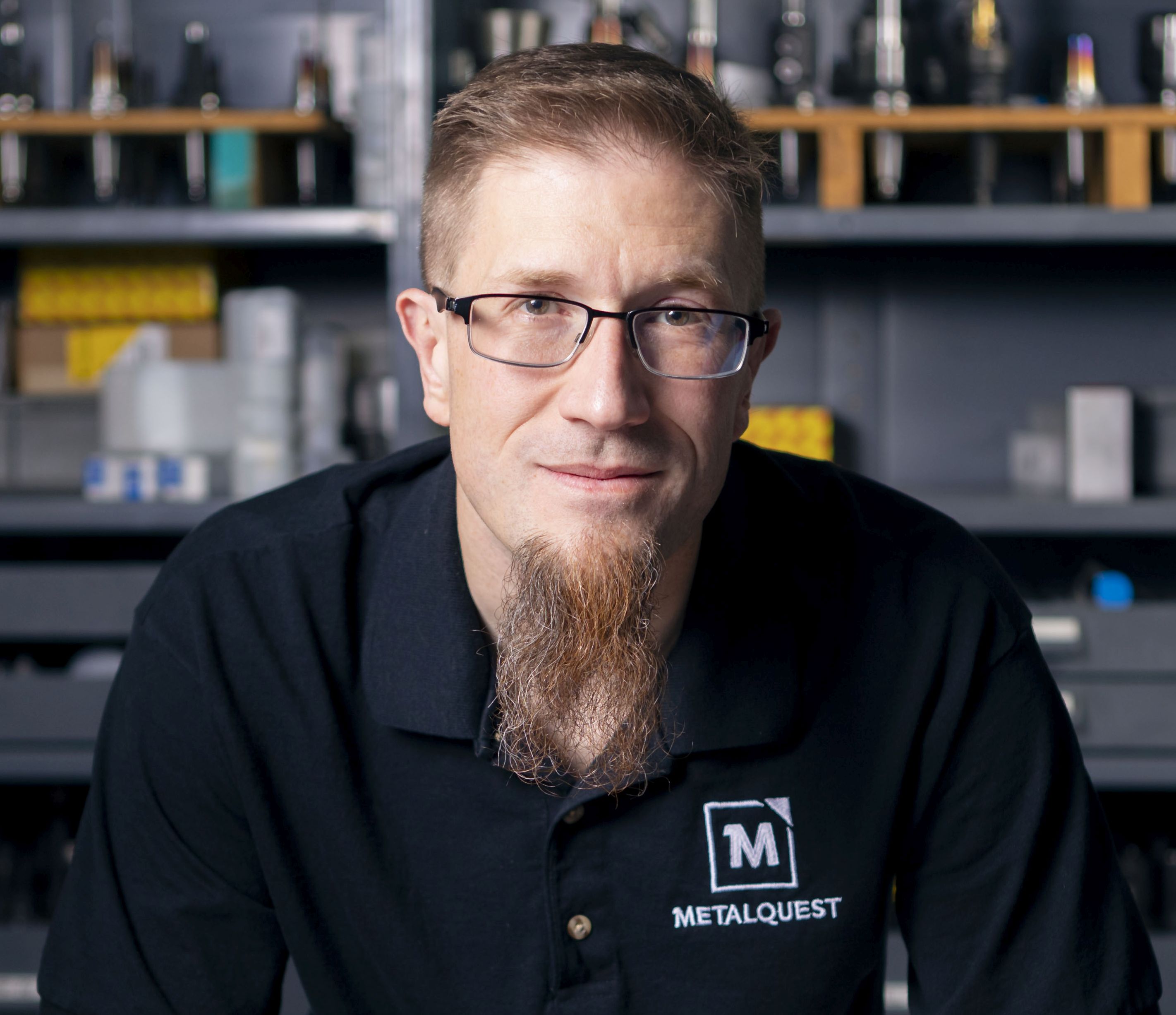 Scott Volk of MetalQuest in shop wearing blue polo and looking at the camera. 